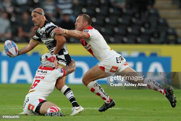 Danny Houghton of Hull FC is tackled by James Roby and Theo Fages of St Helens during the BetFred Super League match between Hull FC and St Helens...