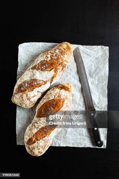 black bread and a knife for cutting bread - bread knife stock-fotos und bilder