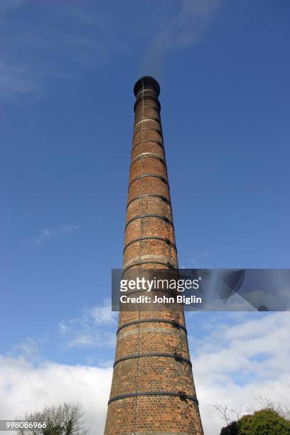 tall brick chimney - tufsteenrots stockfoto's en -beelden