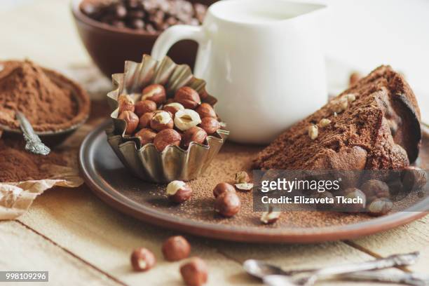 piece of chocolate cake, hazelnuts and jar with milk - chocolate milk stock pictures, royalty-free photos & images