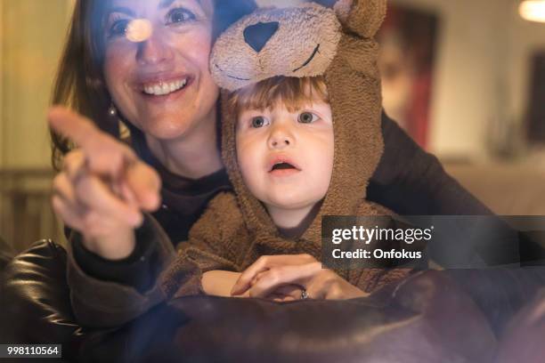 小男孩裡面熊服裝看槽視窗與媽媽 - bear suit 個照片及圖片檔