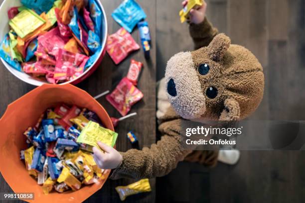 可愛的小男孩裡面熊服裝吃或抓糖果 - bear suit 個照片及圖片檔