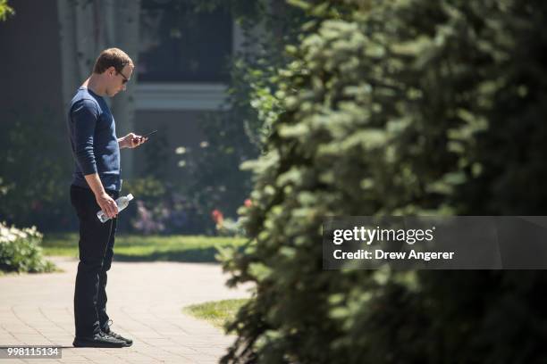 Mark Zuckerberg, chief executive officer of Facebook, checks his phone during the annual Allen & Company Sun Valley Conference, July 13, 2018 in Sun...