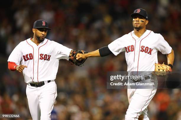 Xander Bogaerts high fives Eduardo Nunez of the Boston Red Sox after turning a double play in the sixth inning of a game against the Texas Rangers at...