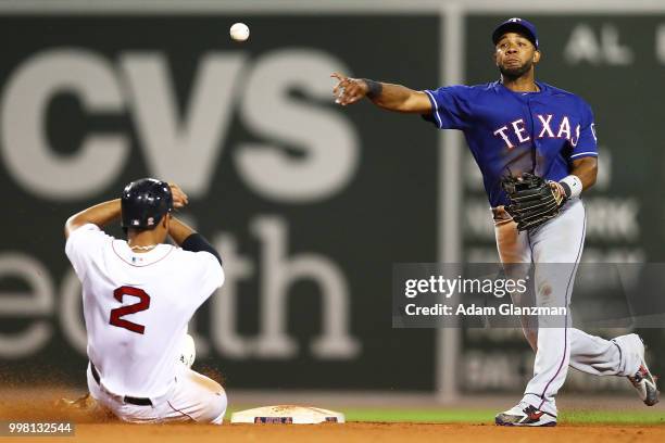 Elvis Andrus of the Texas Rangers turns a double play over the slide of Xander Bogaerts of the Boston Red Sox in the eighth inning of a game at...