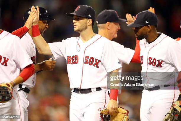 Andrew Benintendi of the Boston Red Sox high five this teammates after victory over the Texas Rangers at Fenway Park on July 11, 2018 in Boston,...
