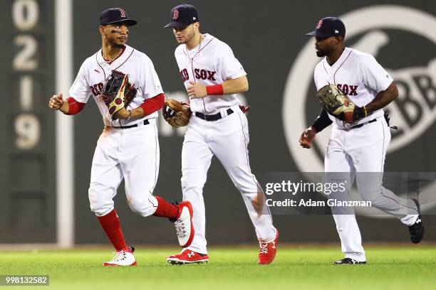 Mookie Betts, Andrew Benintendi and Jackie Bradley Jr. #19 of the Boston Red Sox react after victory over the Texas Rangers at Fenway Park on July...