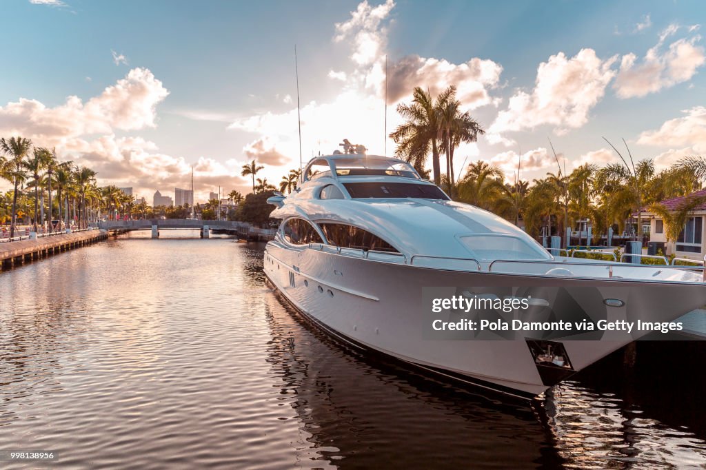 Front view of the sun coming down at sunset in Fort Lauderdale canals. Luxury yachts in Las Olas Boulevard, Florida, USA