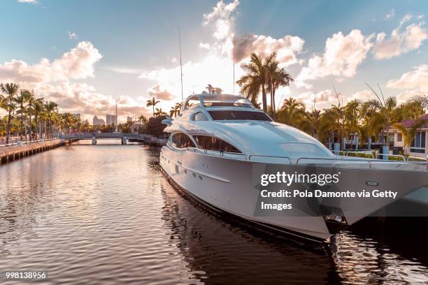 front view of the sun coming down at sunset in fort lauderdale canals. luxury yachts in las olas boulevard, florida, usa - yacht photos et images de collection