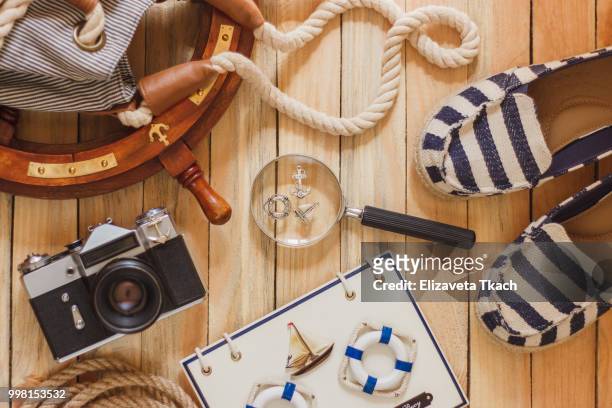 striped slippers, camera, bag and maritime decorations on the wooden background - camera bag stock-fotos und bilder