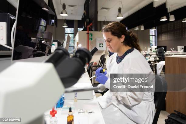 science researcher with a microscope - david freund stockfoto's en -beelden