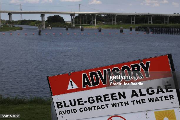 Sign warns of Blue-Green algae in the water near the Port Mayaca Lock and Dam on Lake Okeechobee on July 13, 2018 in Port Mayaca, Florida. Water...