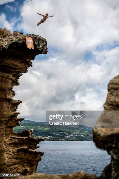 In this handout image provided by Red Bull, Andy Jones of the USA dives from a 25 metre cliff at the Snakehead on Islet Vila Franco do Campo during...