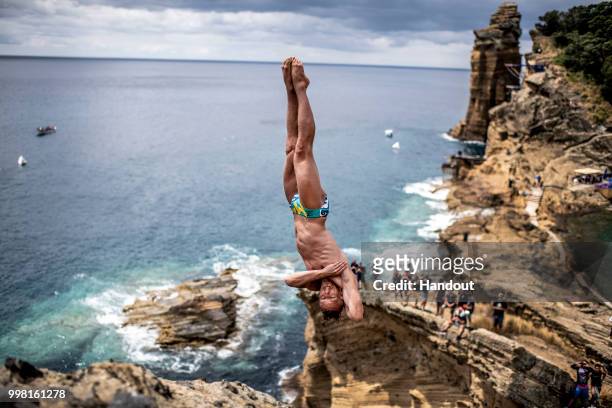 In this handout image provided by Red Bull, Kris Kolanus of Poland dives from a 25 metre cliff at the Snakehead on Islet Vila Franco do Campo during...
