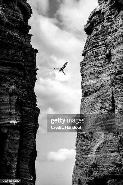 In this handout image provided by Red Bull, Kris Kolanus of Poland dives from a 27 metre cliff face on Islet Vila Franco do Campo during the first...