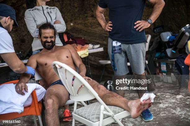 In this handout image provided by Red Bull, Orlando Duque of Colombia gets treated after he injured himself on Islet Vila Franca do Campo during the...