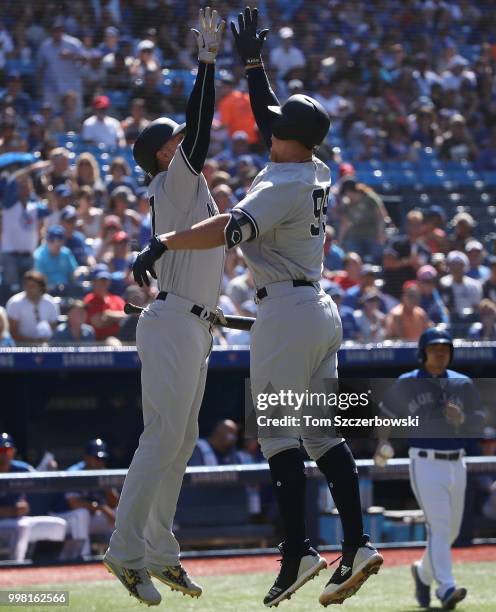 Aaron Judge of the New York Yankees is congratulated by Giancarlo Stanton after hitting a solo home run in the first inning during MLB game action...