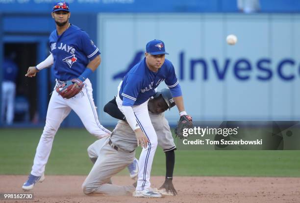 Aledmys Diaz of the Toronto Blue Jays collides with Didi Gregorius of the New York Yankees as Gregorius arrives at second base safely but Diaz throws...