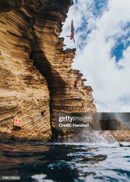 In this handout image provided by Red Bull, Kris Kolanus of Poland dives from a 25 metre cliff at the Snakehead on Islet Vila Franco do Campo during...