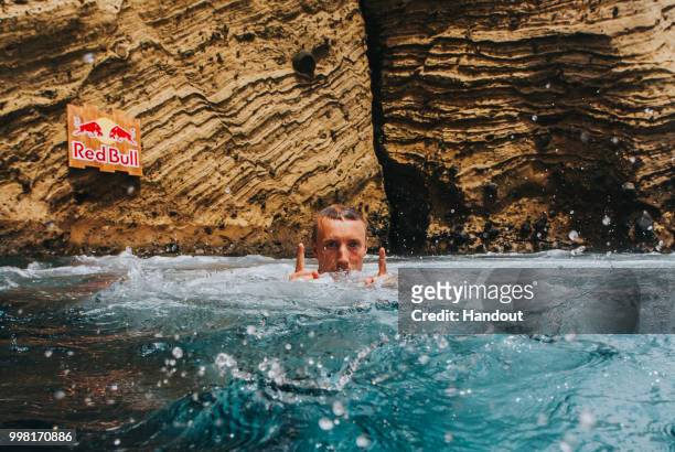 In this handout image provided by Red Bull, Kris Kolanus of Poland reacts after diving from a 25 metre cliff at the Snakehead on Islet Vila Franco do...