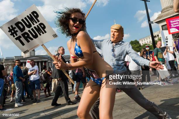 Man wearing Donald Trump mask dances with protesters during Together Against Trump march through central London followed by a rally in Trafalgar...