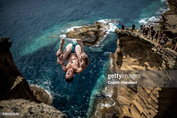 In this handout image provided by Red Bull, Steven LoBue of the USA dives from a 25 metre cliff at the Snakehead on Islet Vila Franco do Campo during...