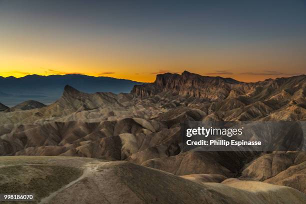 sunset at death valley's zabrinskie point - sunset point stock pictures, royalty-free photos & images