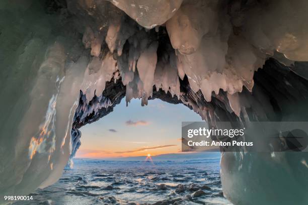 sunset in the ice cave on lake baikal - anton petrus stock pictures, royalty-free photos & images