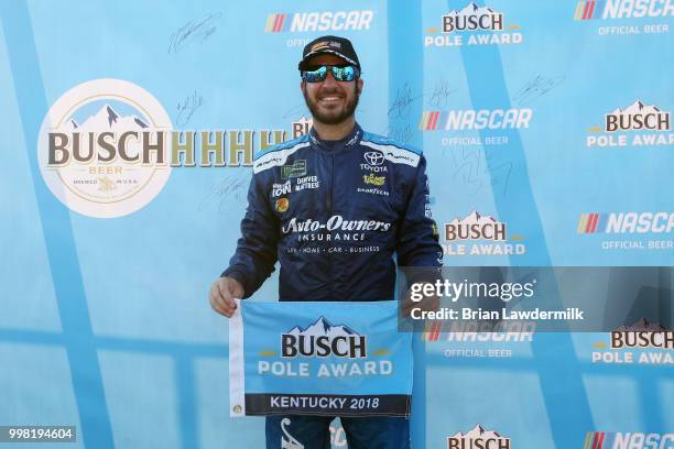 Martin Truex Jr., driver of the Auto-Owners Insurance Toyota, poses with the Busch Pole Award after qualifying for the pole position for the Monster...