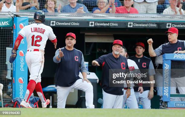 Francisco Lindor of the Cleveland Indians is congratulated by Manager Terry Francona as he returns to the dugout after scoring on a RBI double by...