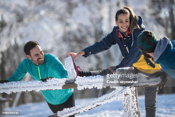 glückliche athleten stretching und sprechen während der wintertag. - skynesher stock-fotos und bilder