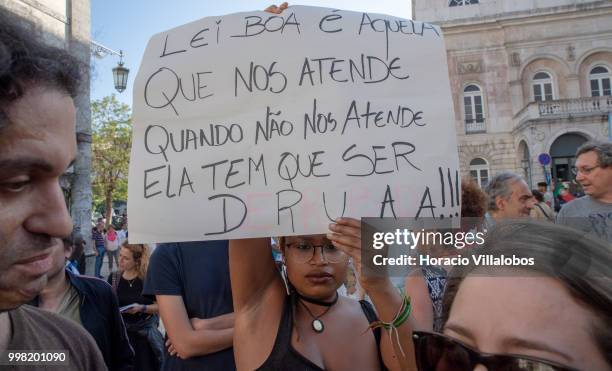 Demonstrator holds a sign stating that bad laws must be repealed during a protest against "acts of racism that daily affect blacks and immigrants...