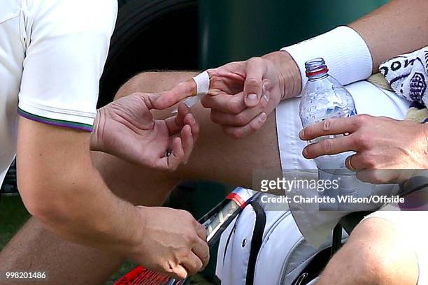 Mens Singles, Semi-Final - Kevin Anderson v John Isner - John Isner has a finger injury dressed at All England Lawn Tennis and Croquet Club on July...