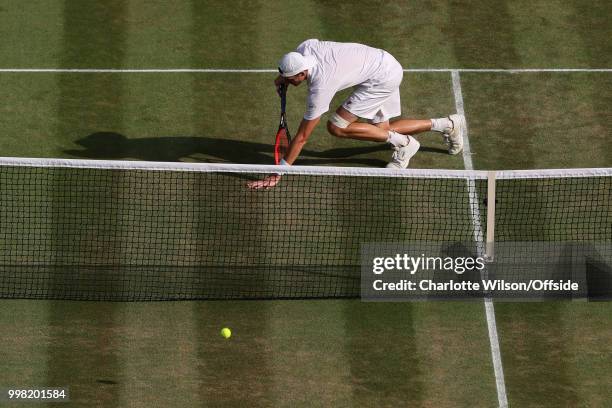 Mens Singles, Semi-Final - Kevin Anderson v John Isner - John Isner leans on his racquet after making a difficult point at All England Lawn Tennis...