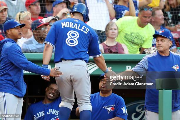 Kendrys Morales of the Toronto Blue Jays returns to the dugout after scoring in the second inning of a game against the Boston Red Sox at Fenway Park...