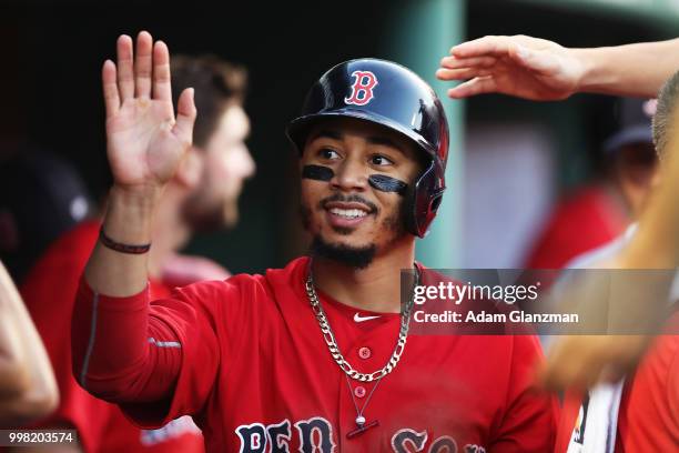 Mookie Betts of the Boston Red Sox returns to the dugout after scoring in the second inning of a game against the Toronto Blue Jays at Fenway Park on...