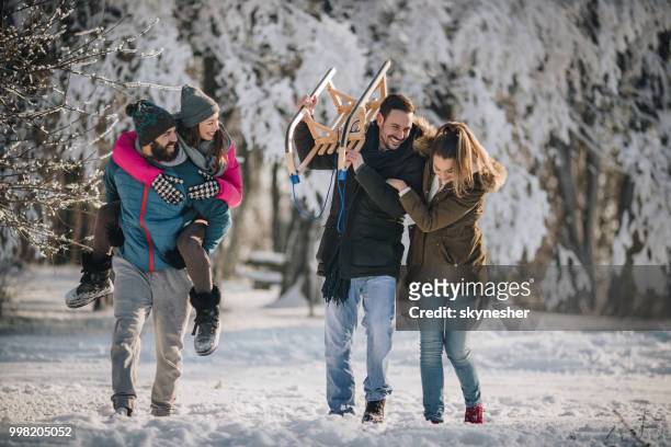 gruppe der happy friends spaß während des gehens auf dem schnee in den park. - skynesher stock-fotos und bilder