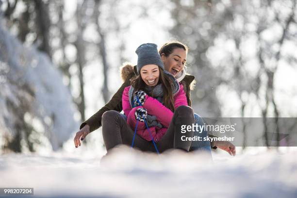 glückliche mädchen spaß beim rodeln auf dem schnee in der natur. - skynesher stock-fotos und bilder