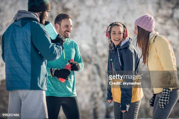 gruppe von glücklichen athleten sprechen auf eine pause in wintertag. - skynesher stock-fotos und bilder