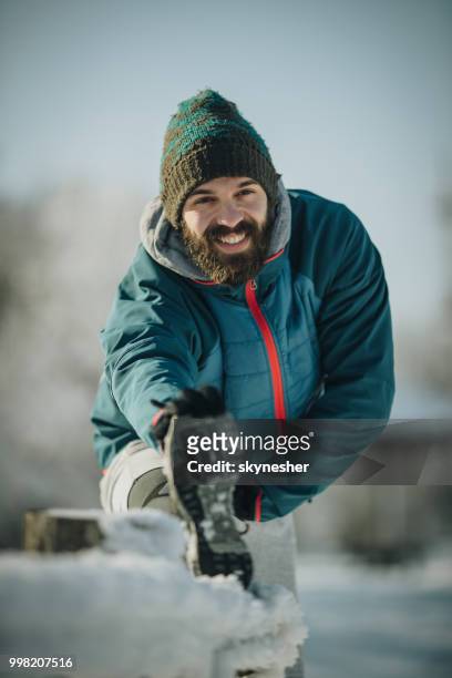 glücklich sportlicher mann streckt sein bein in wintertag. - skynesher stock-fotos und bilder