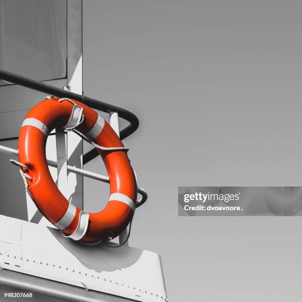 bright orange lifebuoy on a yacht side - life ring buoy stock pictures, royalty-free photos & images
