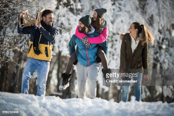 glückliche paare sprechen während des gehens auf dem schnee im park. - skynesher stock-fotos und bilder