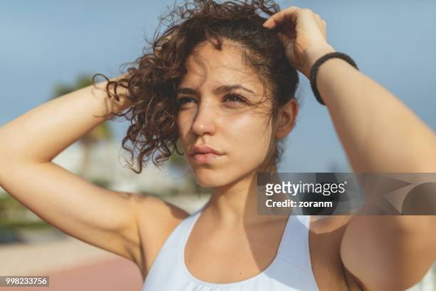 young runner tying hair - zoranm imagens e fotografias de stock
