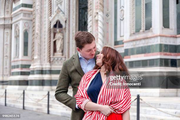 young couple hugging, santa maria del fiore, florence, toscana, italy - fiore stock-fotos und bilder