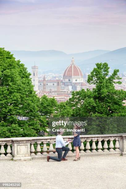 young man proposing to woman, santa maria del fiore in background, florence, toscana, italy - fiore stock pictures, royalty-free photos & images