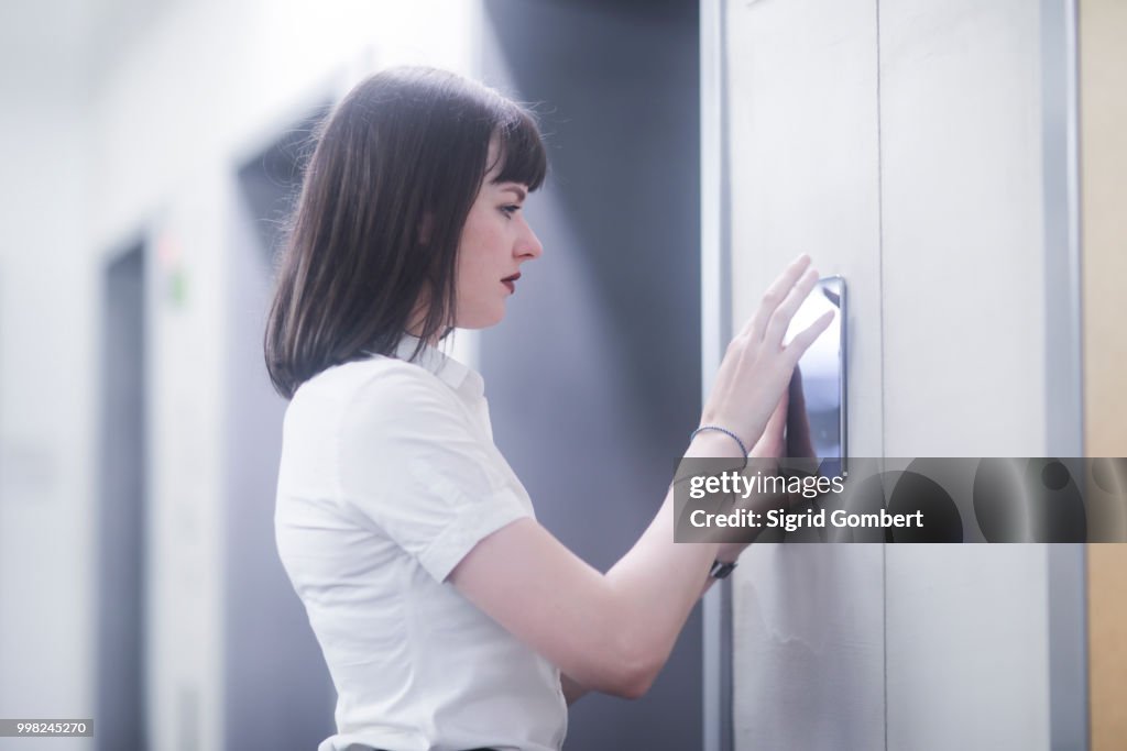 Woman using wall mounted touch screen control panel