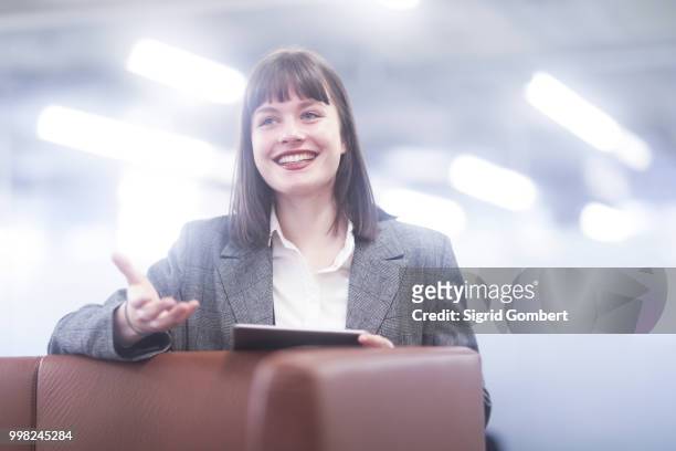 businesswoman in office with digital tablet smiling - sigrid gombert fotografías e imágenes de stock