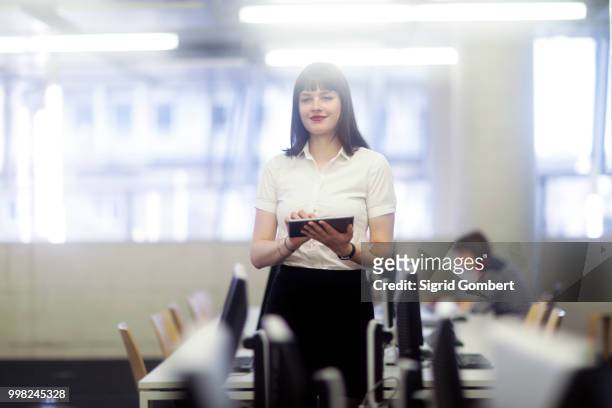 businesswoman in office using digital tablet - sigrid gombert stock pictures, royalty-free photos & images