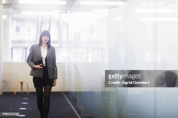 businesswoman in office holding digital tablet - sigrid gombert stock-fotos und bilder