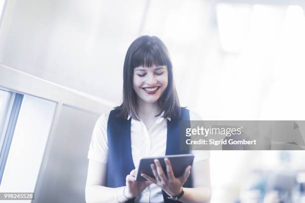 businesswoman using digital tablet - sigrid gombert photos et images de collection